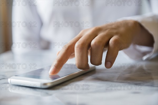 Finger of African American woman using cell phone