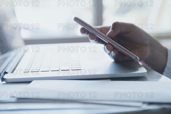 Hand of African American woman texting on cell phone