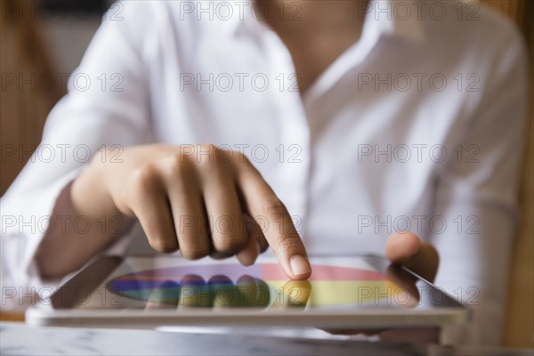 Finger of African American woman using digital tablet