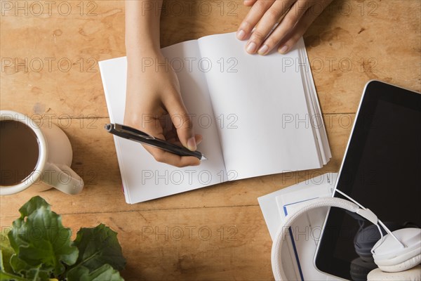 Hands of African American woman writing in journal