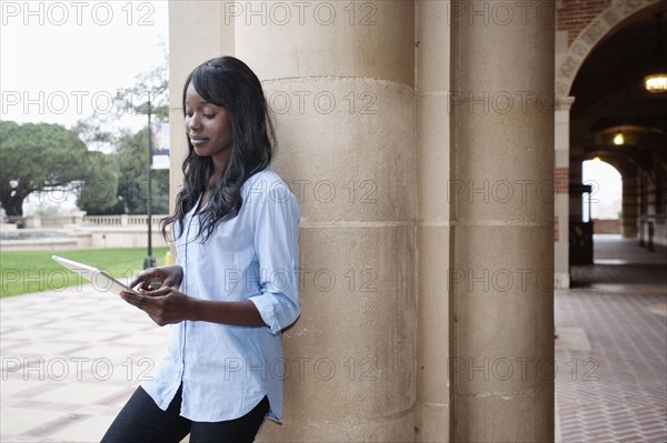 African American student using digital tablet outdoors