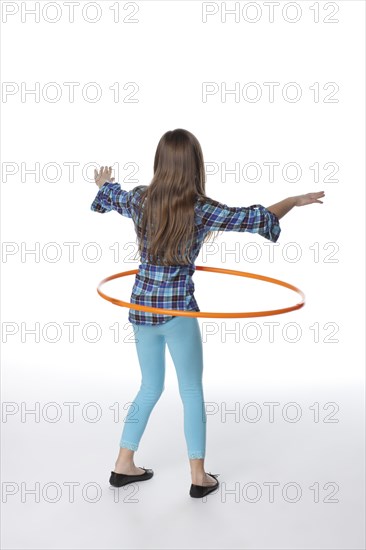 Caucasian girl twirling plastic hoop
