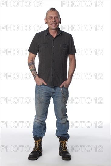 Tattooed Caucasian man with hands in pockets