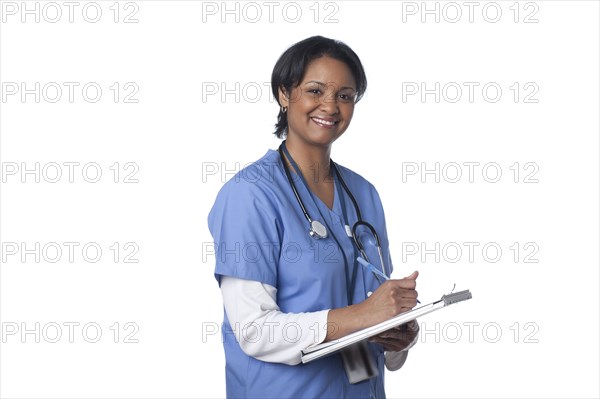 Mixed race doctor writing in medical chart