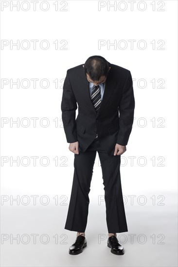 Chinese businessman looking at his shoes