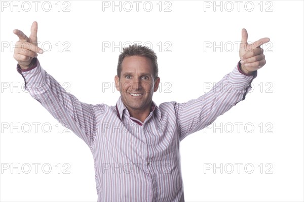 Smiling man with arms outstretched pointing