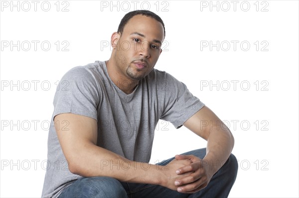 Serious mixed race man with hands clasped