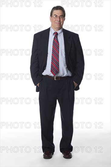 Smiling businessman with hands in pockets