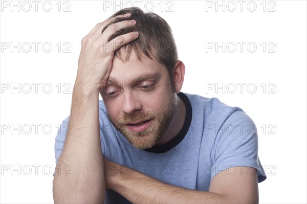 Caucasian man with head in hands