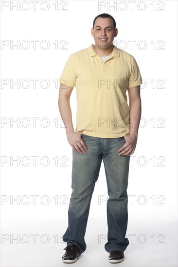 Smiling Hispanic man with hands in pockets