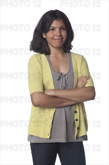 Smiling Hispanic teenager with arms crossed