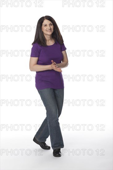 Smiling Caucasian woman with hands clasped