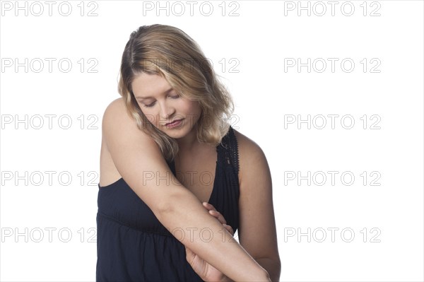 Serious Caucasian woman looking at arm