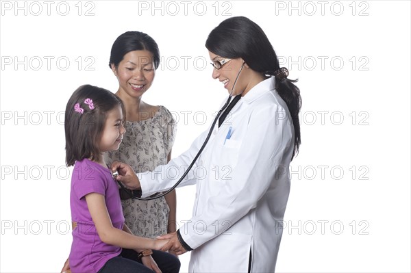 Doctor listening to girl's heartbeat