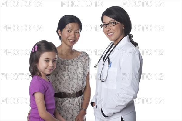 Smiling doctor standing with mother and daughter