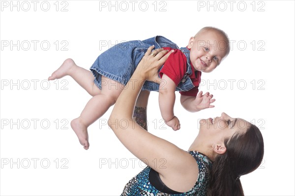 Caucasian mother lifting up son