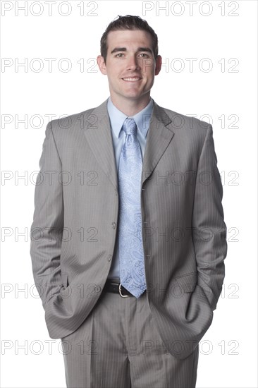 Smiling Caucasian businessman with hands in pockets