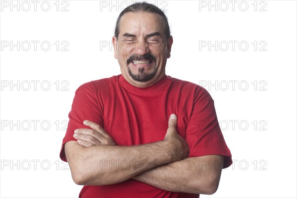 Laughing mixed race man with arms crossed