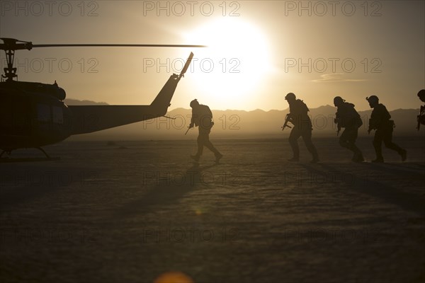 Soldiers boarding helicopter in remote desert
