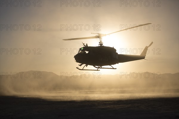 Silhouette of helicopter flying over remote landscape