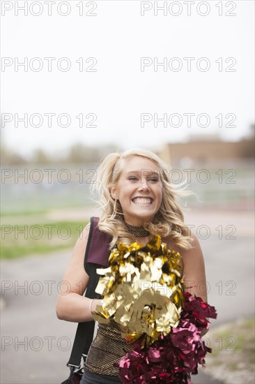 Caucasian cheerleader cheering in parking lot