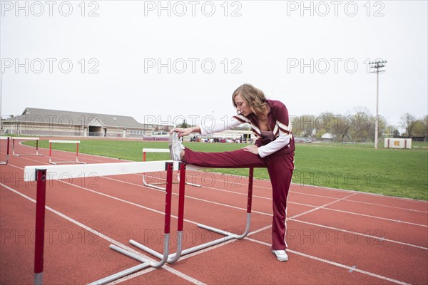 Caucasian cheerleader stretching on track