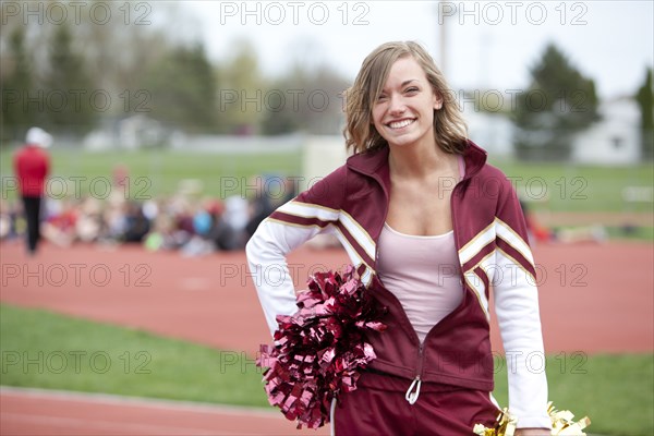 Caucasian cheerleader smiling on track