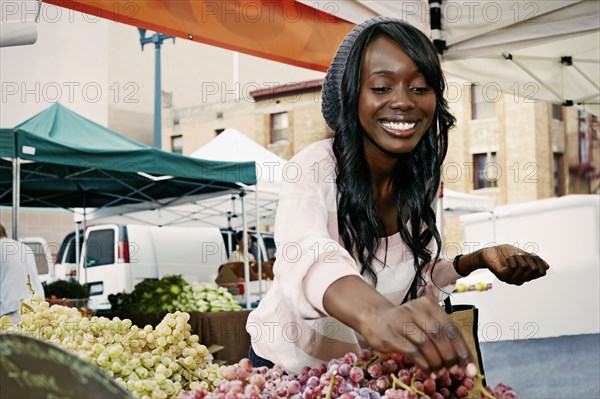 African American woman buying grapes