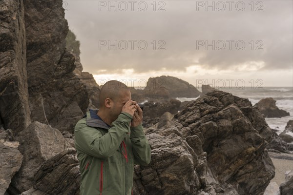 Chinese man photographing ocean