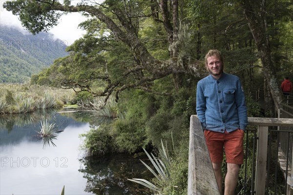 Caucasian man smiling near railing at river