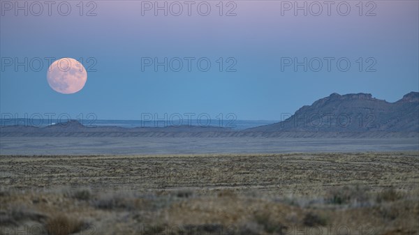 Full moon rising over Navajo Nation desert landscape