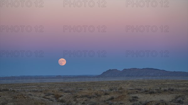 Full moon rising over Navajo Nation desert landscape