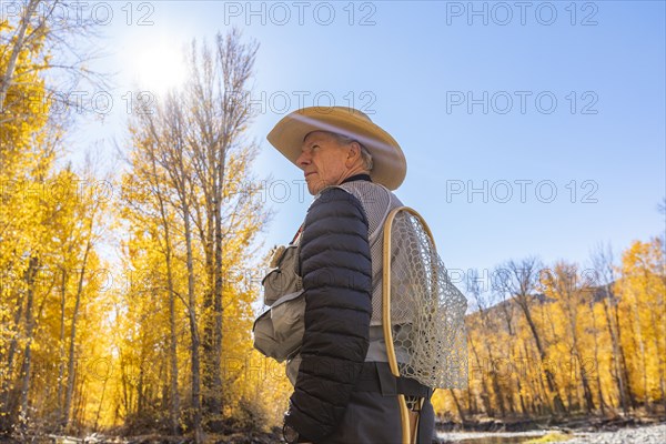 Senior fisherman in Autumn landscape