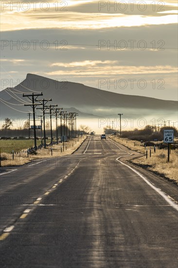 Rural road with mountain and morning mist in distance