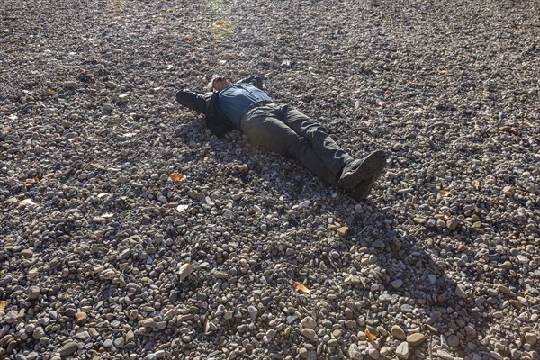 Senior man relaxing of empty river bottom