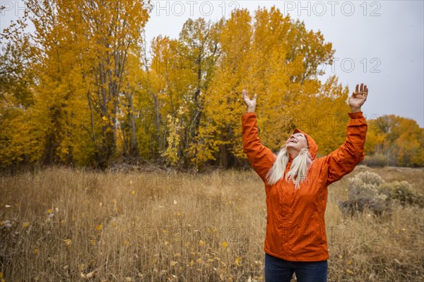 Smiling woman with arms raised