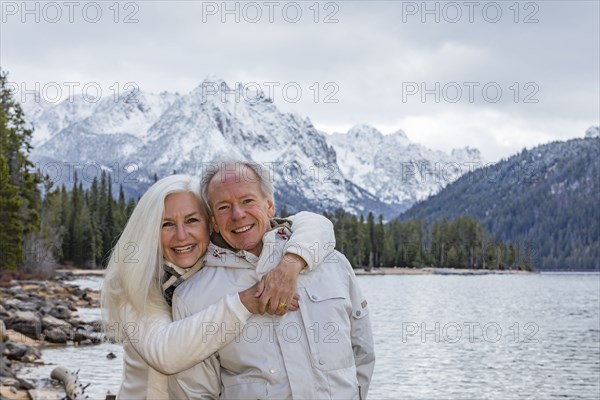 Portrait of smiling senior couple at mountain lake