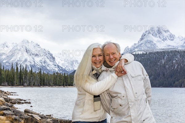 Portrait of smiling senior couple at mountain lake