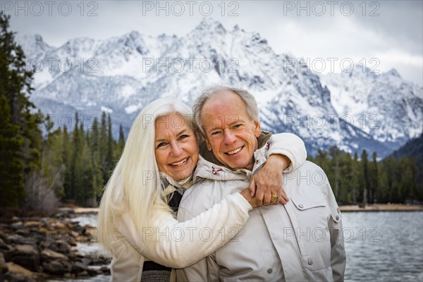 Portrait of smiling senior couple at mountain lake