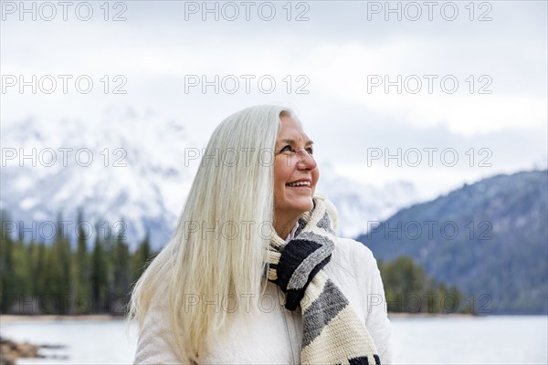 Smiling senior woman at mountain lake