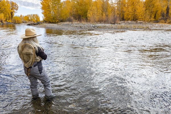 Senior woman fly-fishing