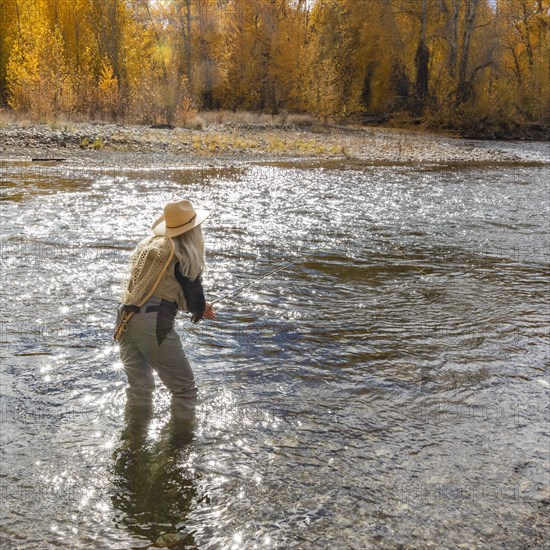 Senior woman fly-fishing