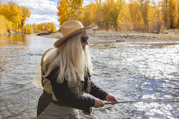 Senior woman fly-fishing