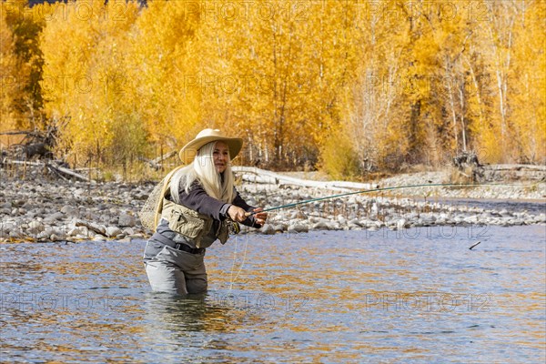 Senior woman fly-fishing