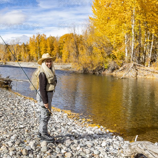 Portrait of senior woman fly-fishing