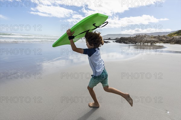 Boy with surfboard on beach