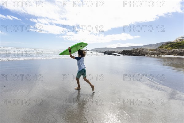 Boy with surfboard on beach