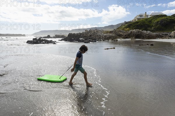 Boy with surfboard on beach