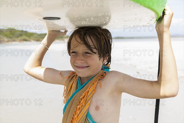 Boy with surfboard on beach