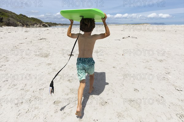 Boy with surfboard on beach